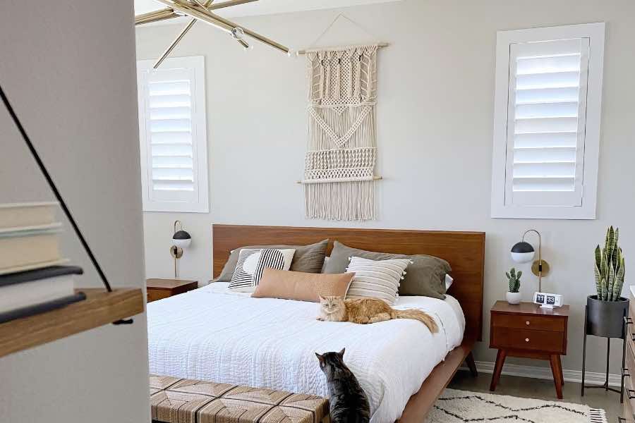 Two cats in a bedroom with Polywood shutters on the windows